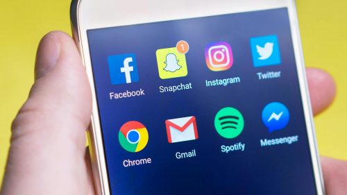 Phone displaying popular social media platforms showcasing the rise of social search in 2025, including TikTok, Instagram, and Pinterest for digital marketing.